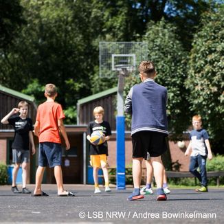 Kinder spielen Basketball